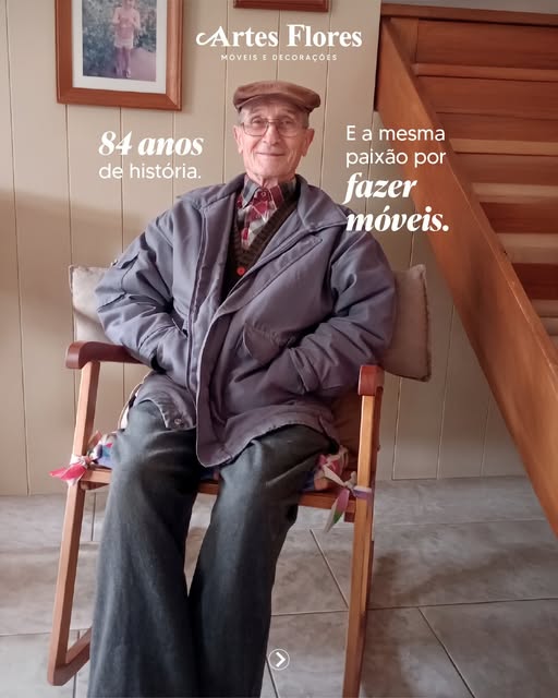 Seu Roberto, fundador da Artes Flores Móveis, sentado em uma cadeira de madeira